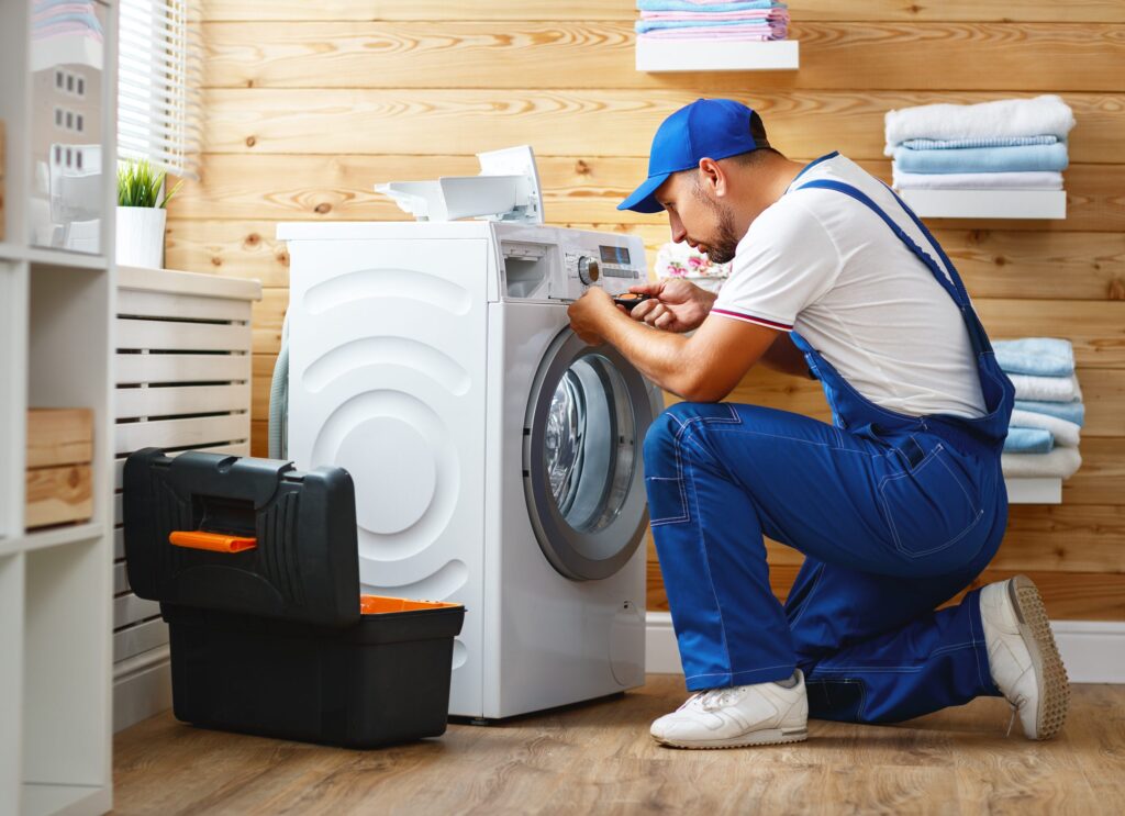 Technician inspecting LG washing machine in Los Angeles home